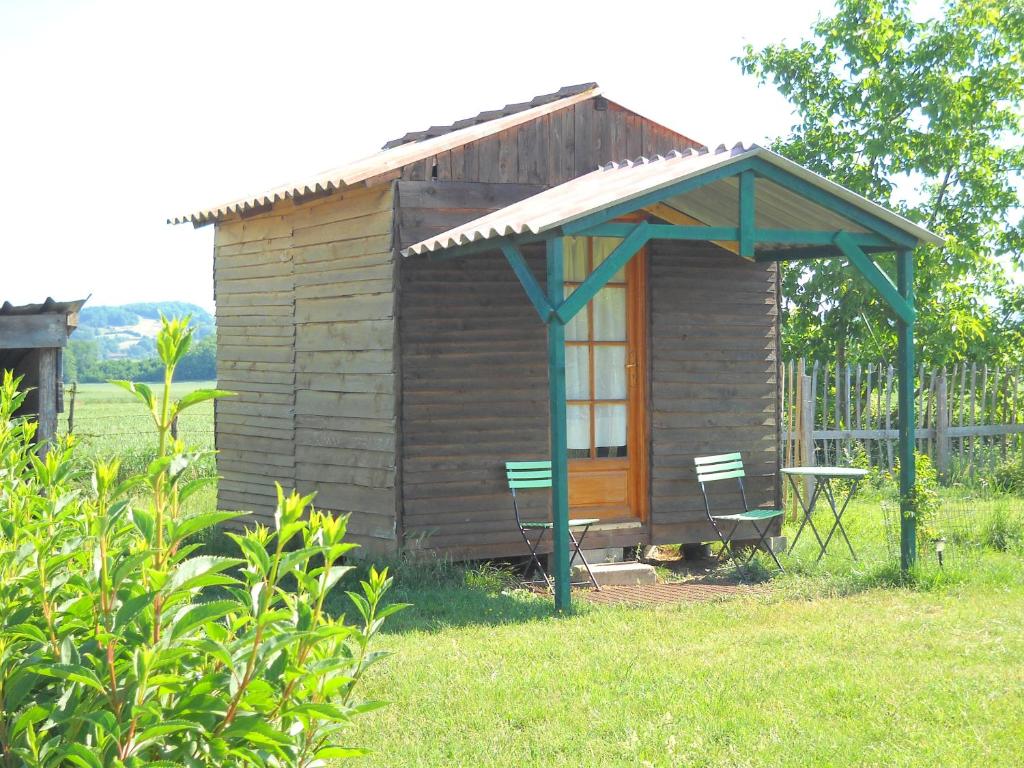 a small wooden cabin with a table and two chairs at Ferme équestre Les Chevaliers in Penol