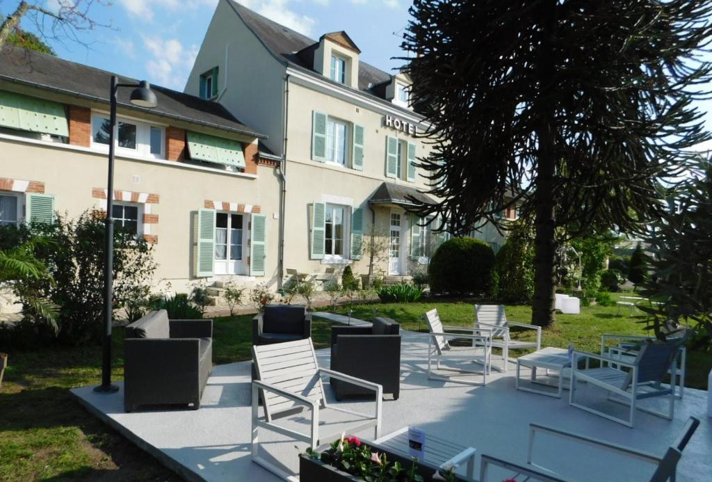 un groupe de chaises et de tables devant un bâtiment dans l'établissement Hotel La Villa Marjane, à Saint-Jean-le-Blanc