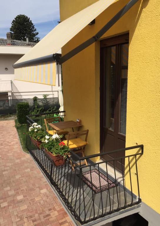 a building with a balcony with a table and flowers at Il Gatto Stanco B&B in Arona