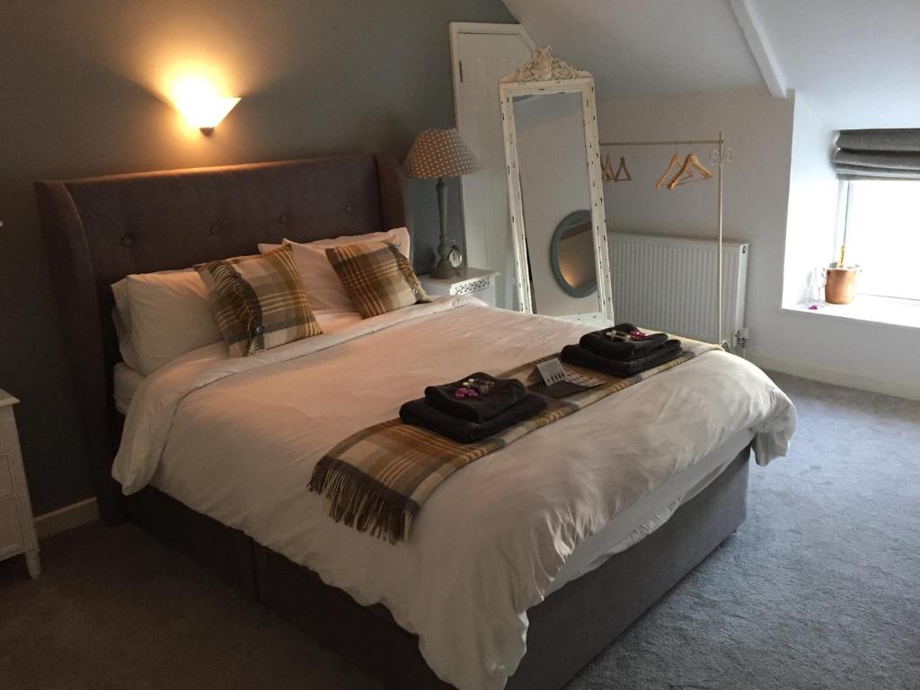 um quarto com uma cama grande e um espelho grande em The Golden Mile Country Inn em Ewenny