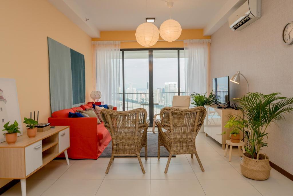 a living room with a red couch and chairs at The Landmark Condo, by Sanguine in George Town