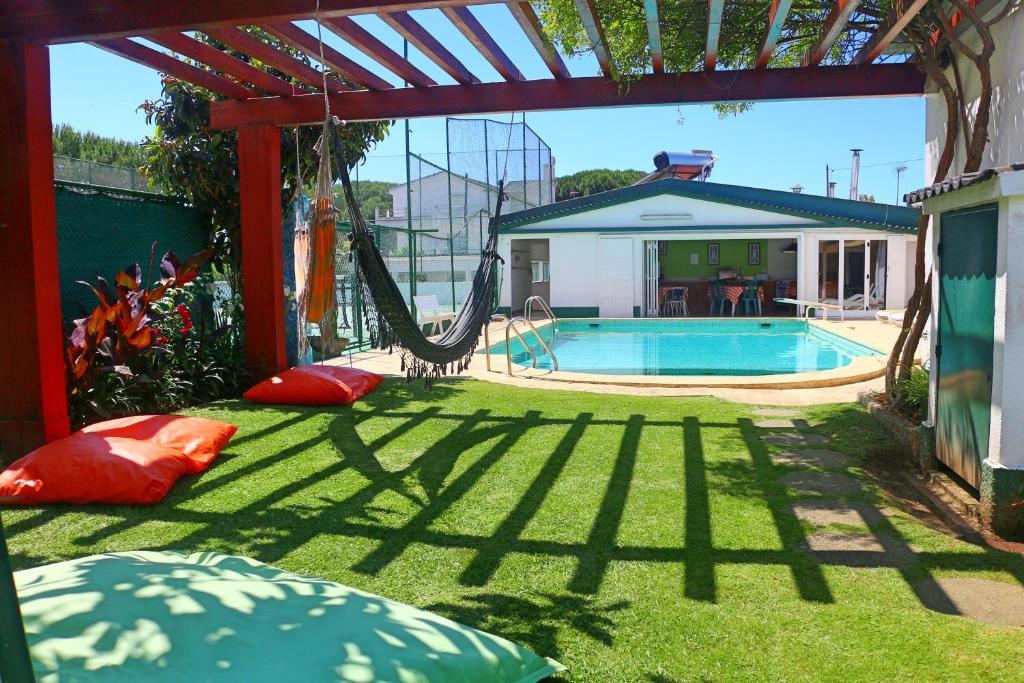 a backyard with a swing and a swimming pool at Manawa Camp in Costa da Caparica