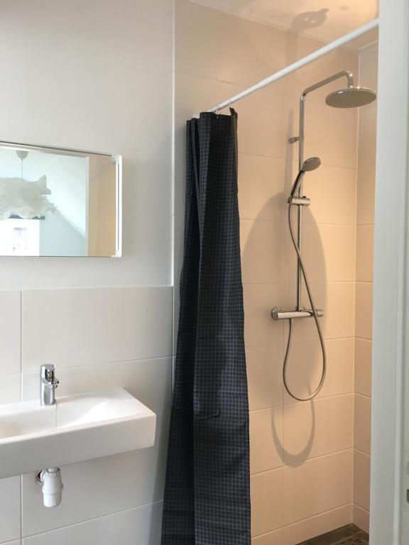 La salle de bains est pourvue d'une douche et d'un lavabo. dans l'établissement Kamers van Goud, à Katwijk aan Zee