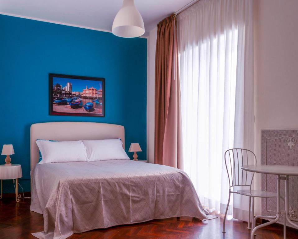 Dormitorio azul con cama y pared azul en Melo Accommodations en Bari