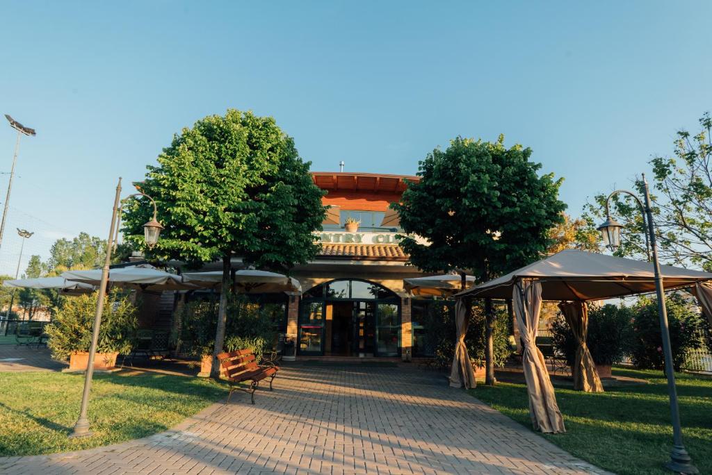 a pavilion with umbrellas in front of a building at Country Club Sport in Alba Adriatica