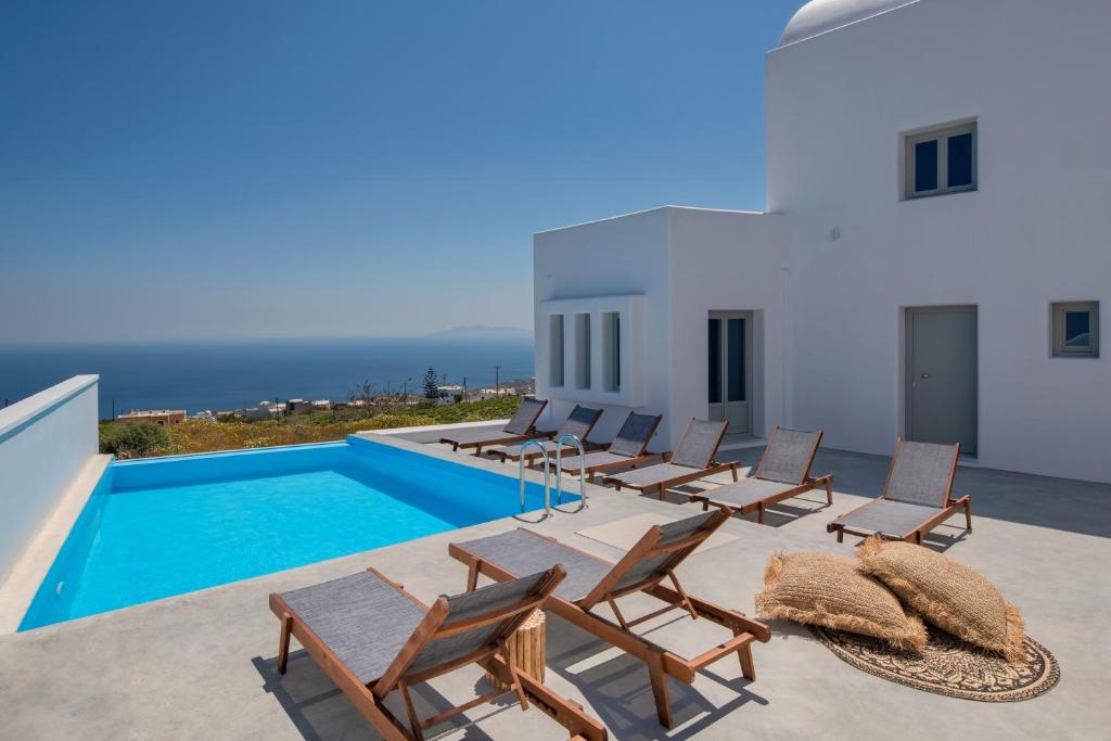 a group of chairs and a swimming pool on a house at Seven Suites in Imerovigli
