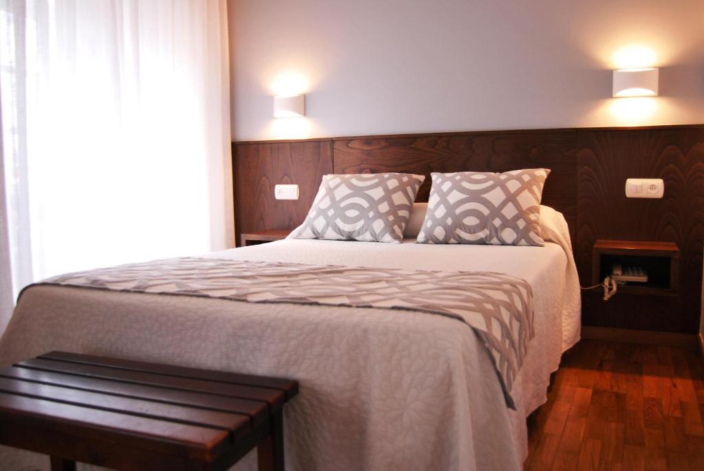 a bedroom with a large bed with two pillows at Hotel Restaurante Elisardo in Noya