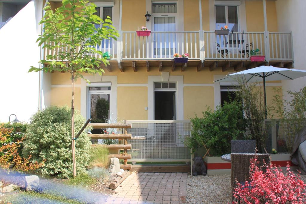 a house with a balcony and a patio at Le Logis GOUT - L'Oustal in Carcassonne