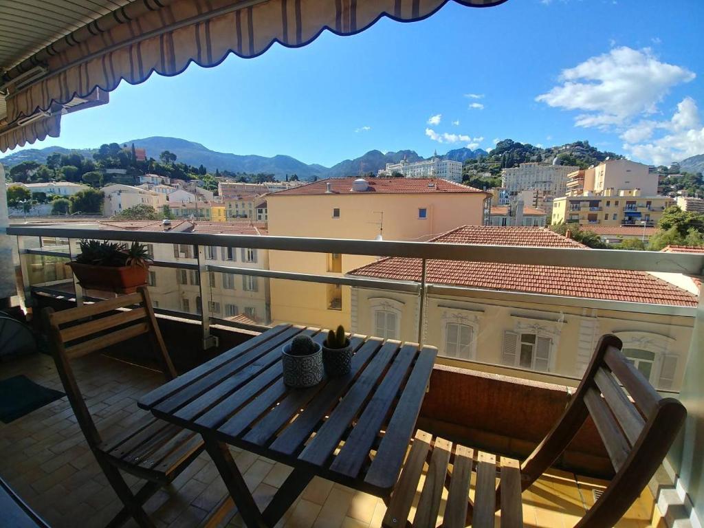 una mesa y sillas en un balcón con vistas en Studio avec Parking Privé au Cœur de la Ville, en Menton