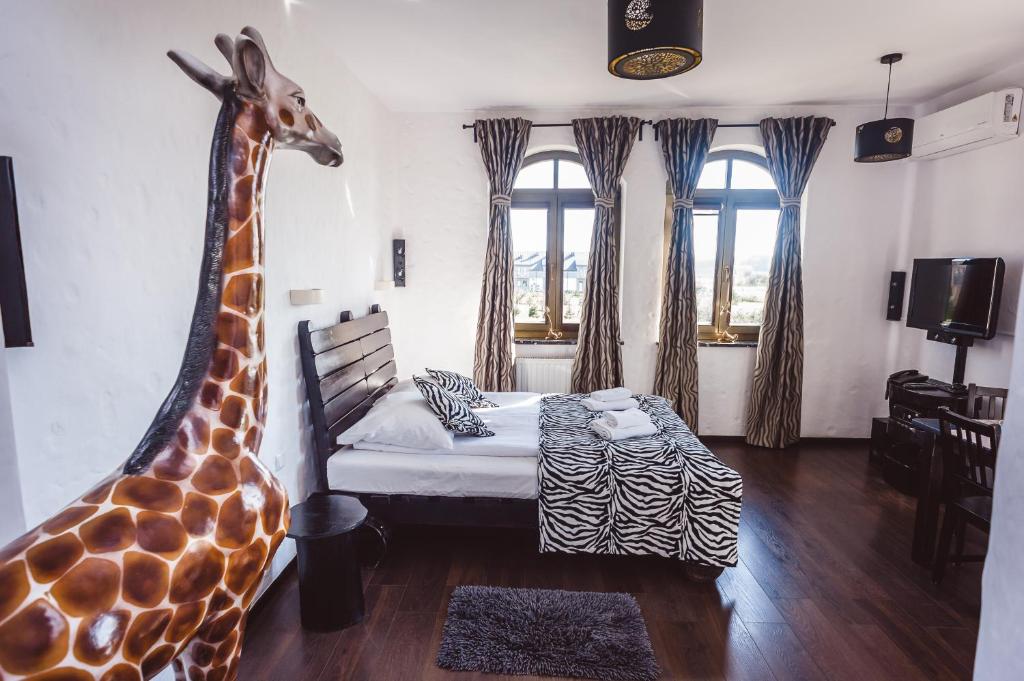 a room with a bed with a giraffe head on the wall at Pensjonat Kolory Świata in Solec-Zdrój