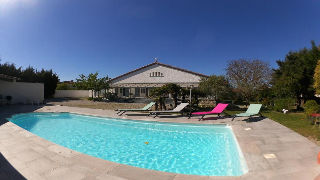 a swimming pool with chairs and a house at Aux Belles Vacances - Adult Only in Caux-et-Sauzens