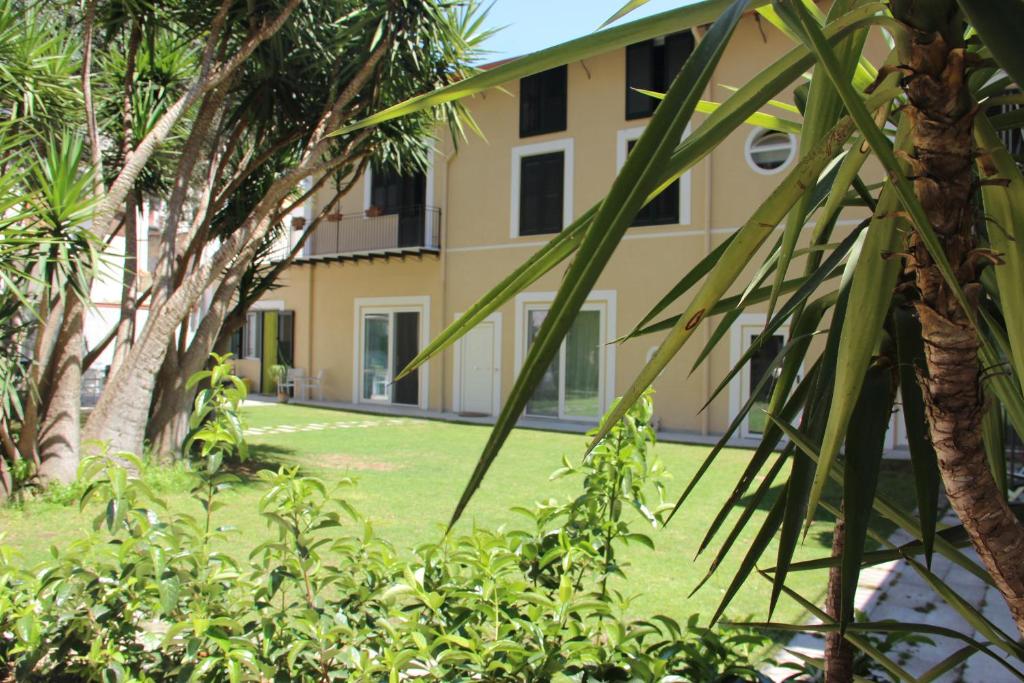una vista de un edificio desde detrás de unas palmeras en Corte del Merlo, en Palermo