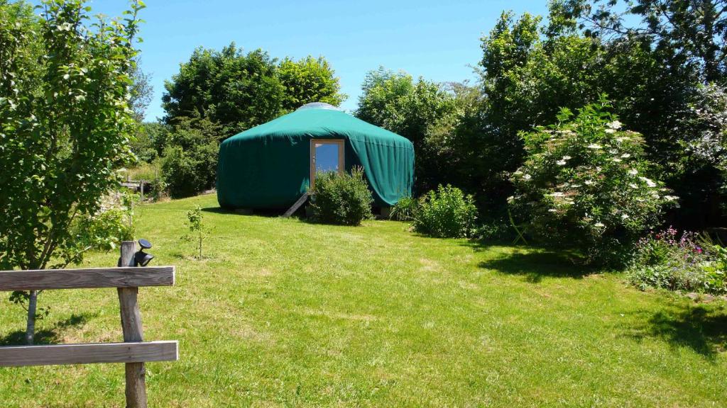 a green tent in the middle of a yard at La Yourte in Moussages
