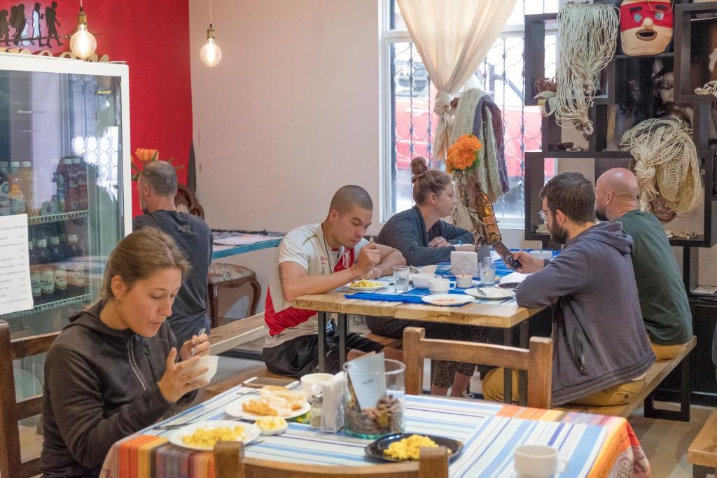 un grupo de personas sentadas en mesas en un restaurante en Casa CarpeDM, en Quito