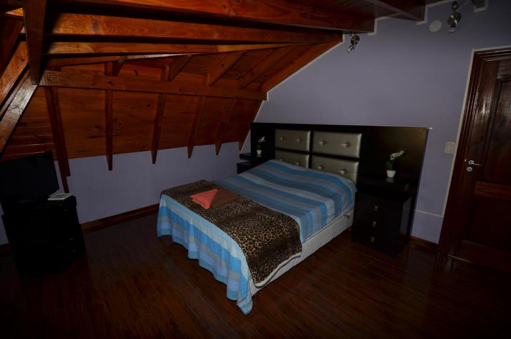 ein Schlafzimmer mit einem Bett in einem Zimmer mit Holzdecken in der Unterkunft Casa Marina Argentina de Aeropuerto Ezeiza chek-in 24 h in Monte Grande