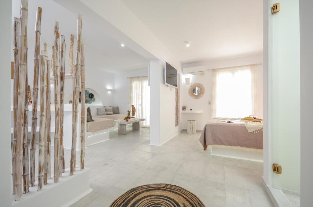 a white bedroom with a bed and a living room at Naxos Hotel Poseidon in Naxos Chora