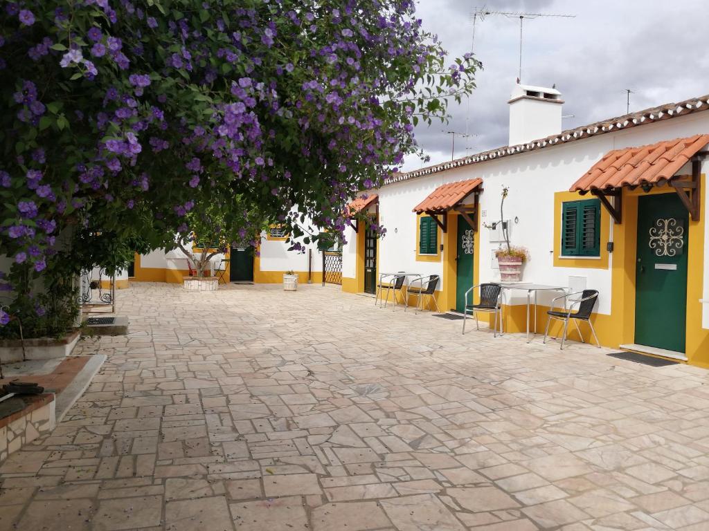 a courtyard of a building with purple flowers at Vitória House in Évora