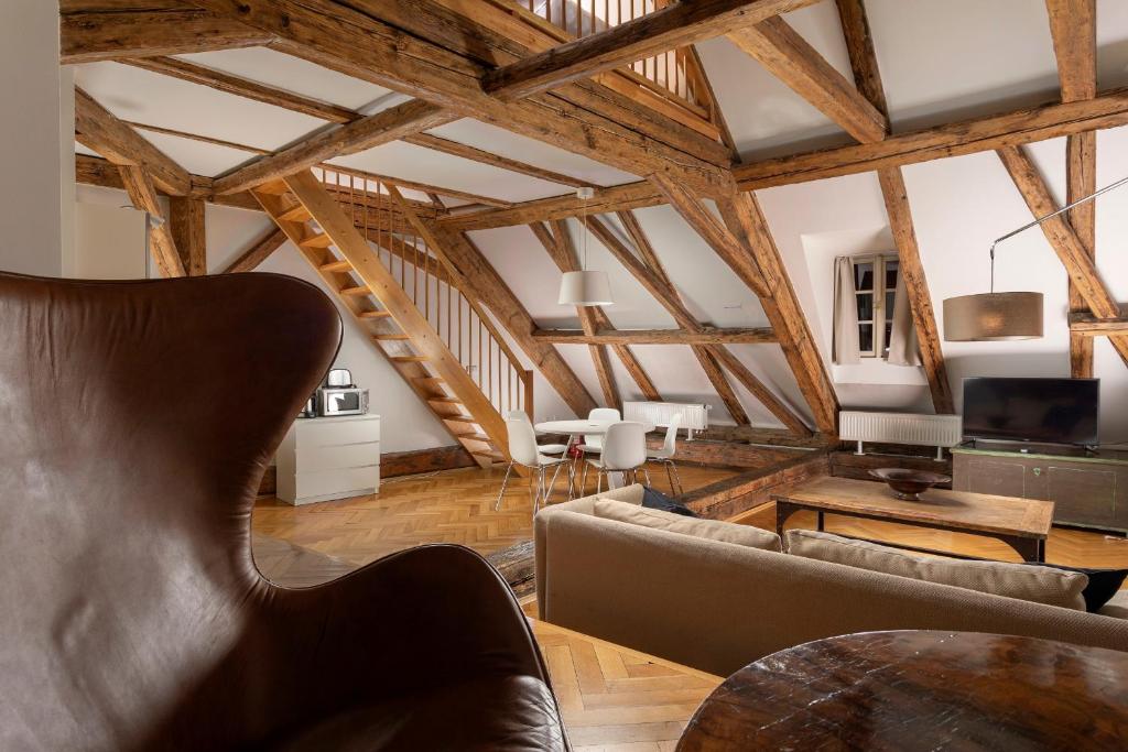 a living room with wooden ceilings and a table at Three Golden Crowns Apartments in Prague