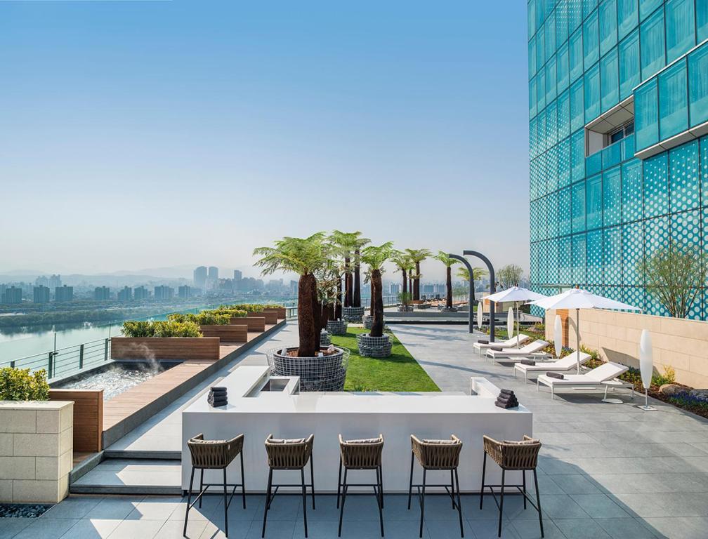 a patio with chairs and a table and a building at Vista Walkerhill Seoul - formerly W Seoul in Seoul