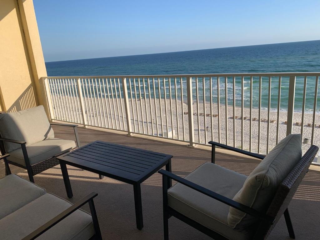 a balcony with chairs and a table and the beach at Ocean Reef 2 bedroom/2 bath! in Panama City Beach