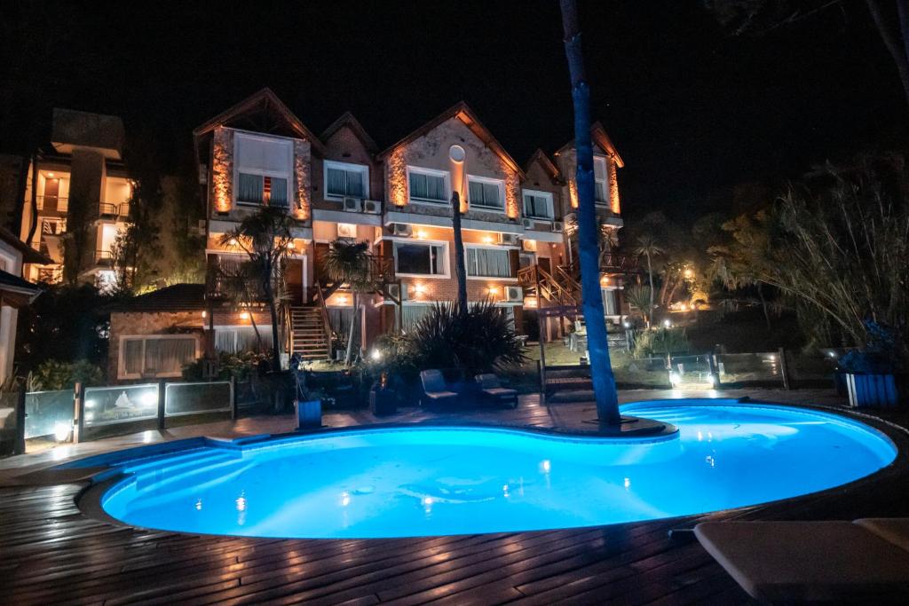 een zwembad voor een huis 's nachts bij Haras del Bosque in Mar de las Pampas