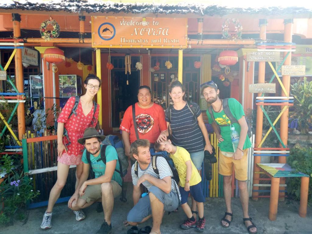 eine Gruppe von Personen, die sich vor einem Gebäude für ein Bild ausgeben in der Unterkunft Novita Homestay in Bunaken