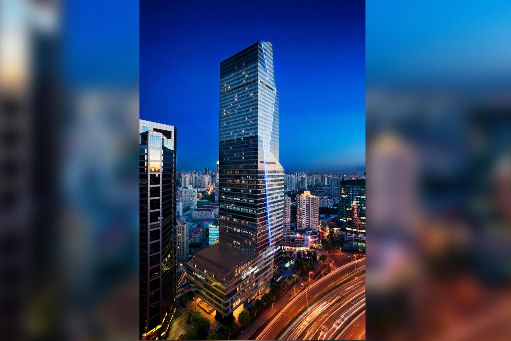 a tall building in a city at night at The Longemont Shanghai in Shanghai