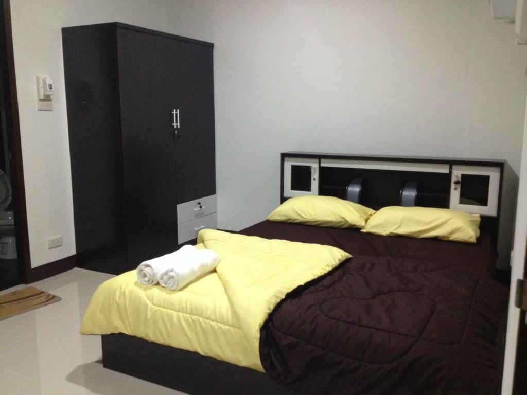 una camera da letto con un grande letto con asciugamani di nana grand a Phrae