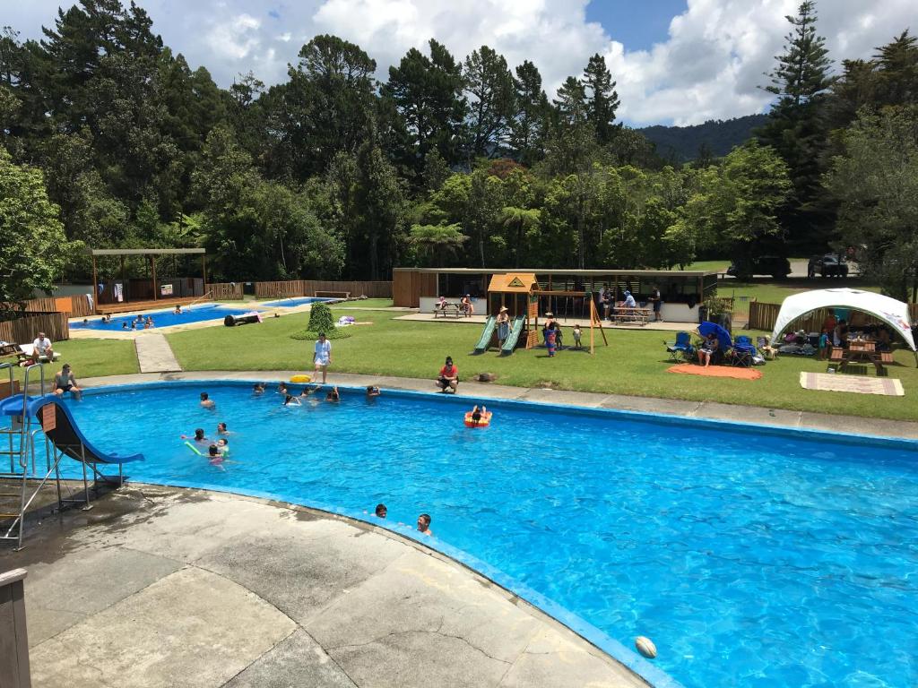 um grupo de pessoas numa grande piscina em Sapphire Springs Holiday Park and Thermal Pools em Katikati