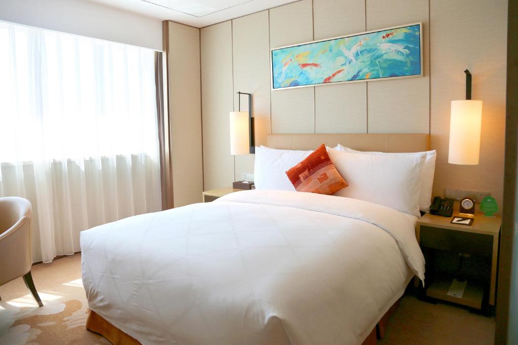 a large white bed in a hotel room at Grand Metropark Hotel Beijing in Beijing