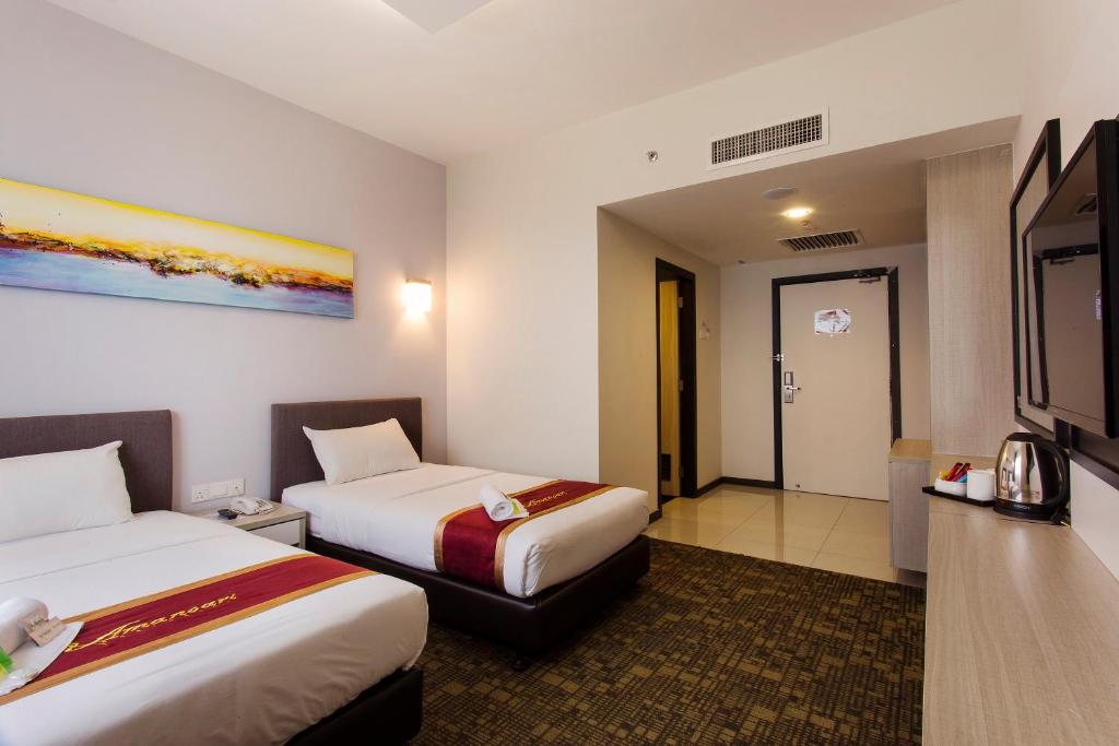 um quarto de hotel com duas camas e uma televisão em Amansari Hotel Nusajaya em Nusajaya