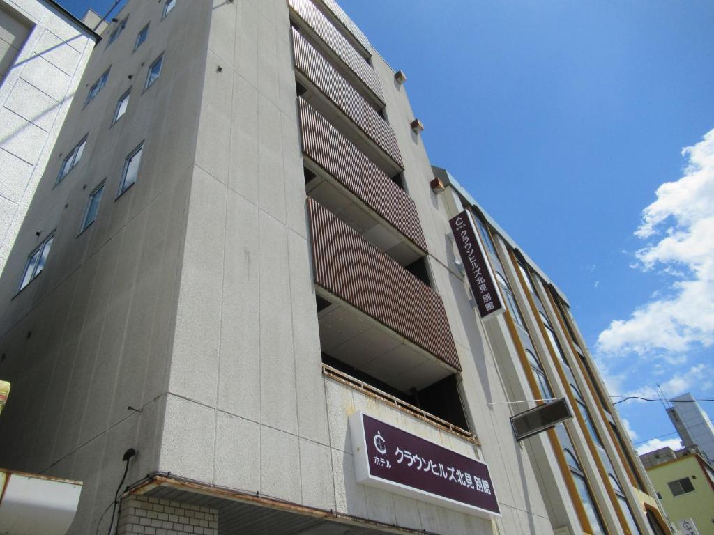 a building with a sign on the side of it at Hotel Crown Hills Kitami Annex in Kitami