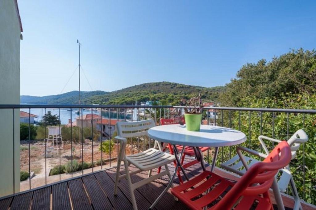 a patio with a table and chairs on a balcony at Apartment Meri - sea view & serenity in Božava