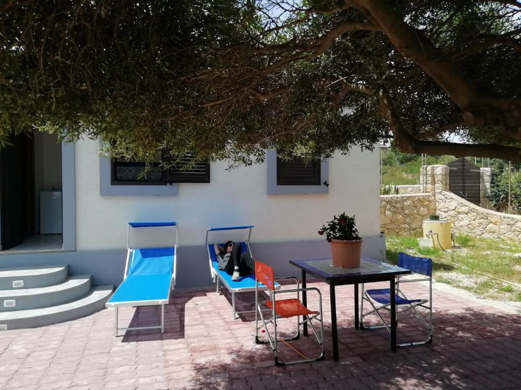 un gruppo di sedie e un tavolo di fronte a una casa di Casuzza cala pisana a Lampedusa