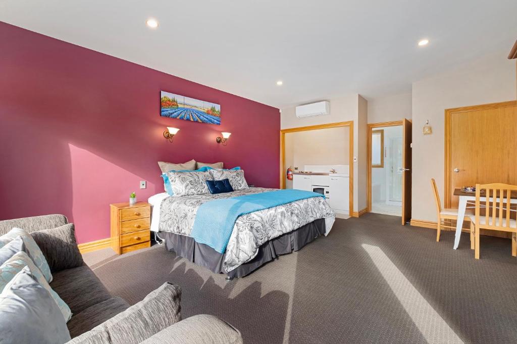 um quarto com uma cama e uma parede roxa em The Shan's Lodge em Queenstown