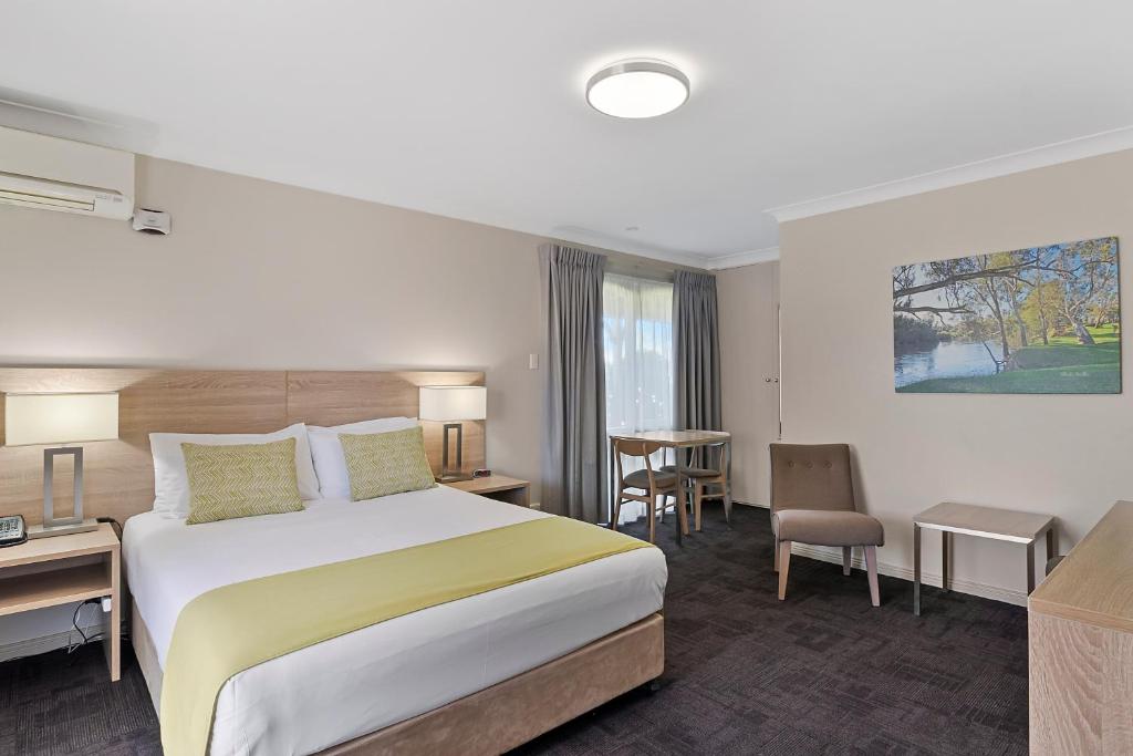 Habitación de hotel con cama y escritorio en Quality Inn Carriage House, en Wagga Wagga