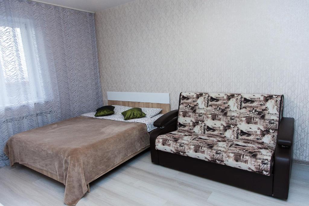 ノヴォシビルスクにあるApartament Antonina near by Marriott hotelのベッドルーム1室(ベッド1台、椅子付)