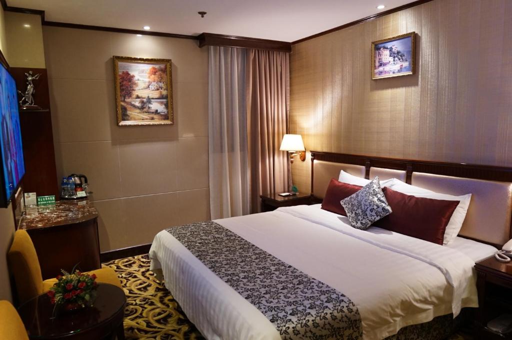 a hotel room with a large bed and a large window at Macau Masters Hotel in Macau