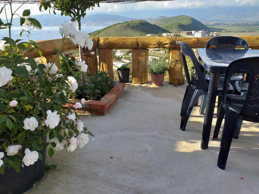 a patio with a table and chairs and flowers at Grand Seaview Apartments in Ksamil