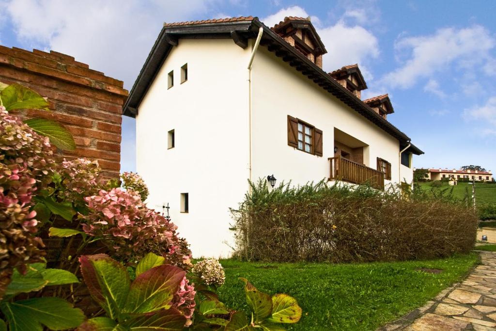 a white house with a black roof at Vivienda Casa Luisa in Comillas