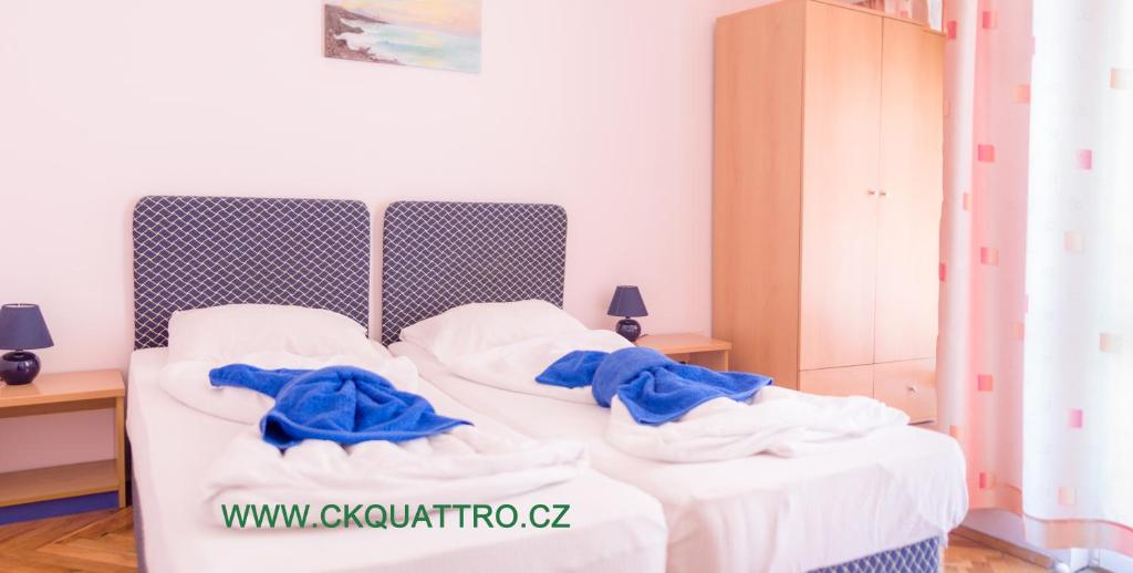 a bed with white sheets and blue towels on it at Penzion DIAMANT in Primorsko