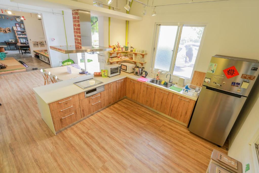a kitchen with wooden cabinets and a stainless steel refrigerator at T-Life Hostel in Longjing