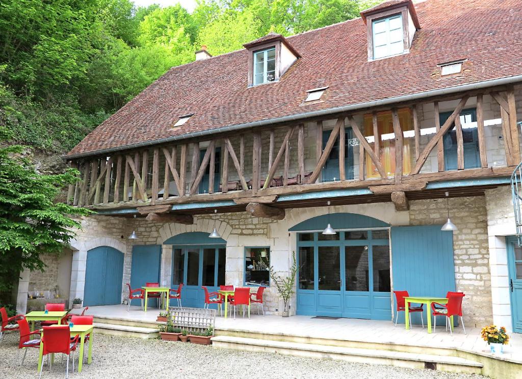 ein Gebäude mit Tischen und Stühlen davor in der Unterkunft La Ferme de la Fosse Dionne in Tonnerre