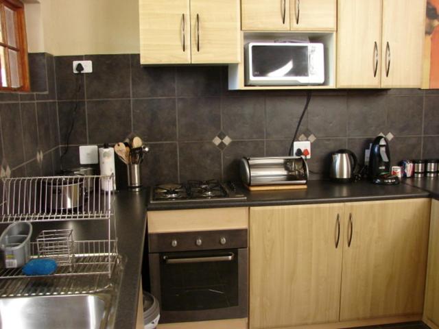 a kitchen with a stove and a microwave at 677Hornbill in Marloth Park