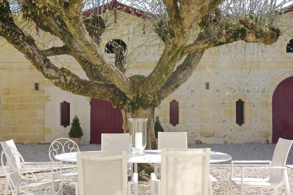 een tafel en stoelen voor een boom bij Domaine St Gilles in Baurech