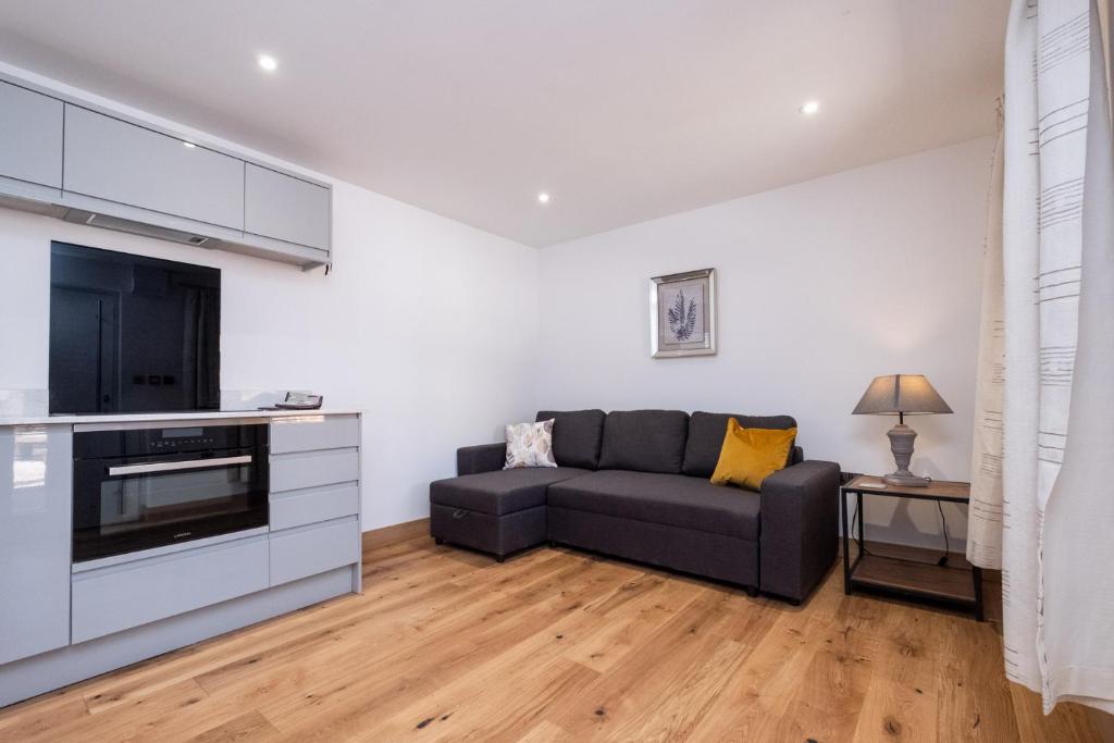 a living room with a couch and a tv at Weeping Willow – Three Tuns Apartments, Pettistree in Pettistree
