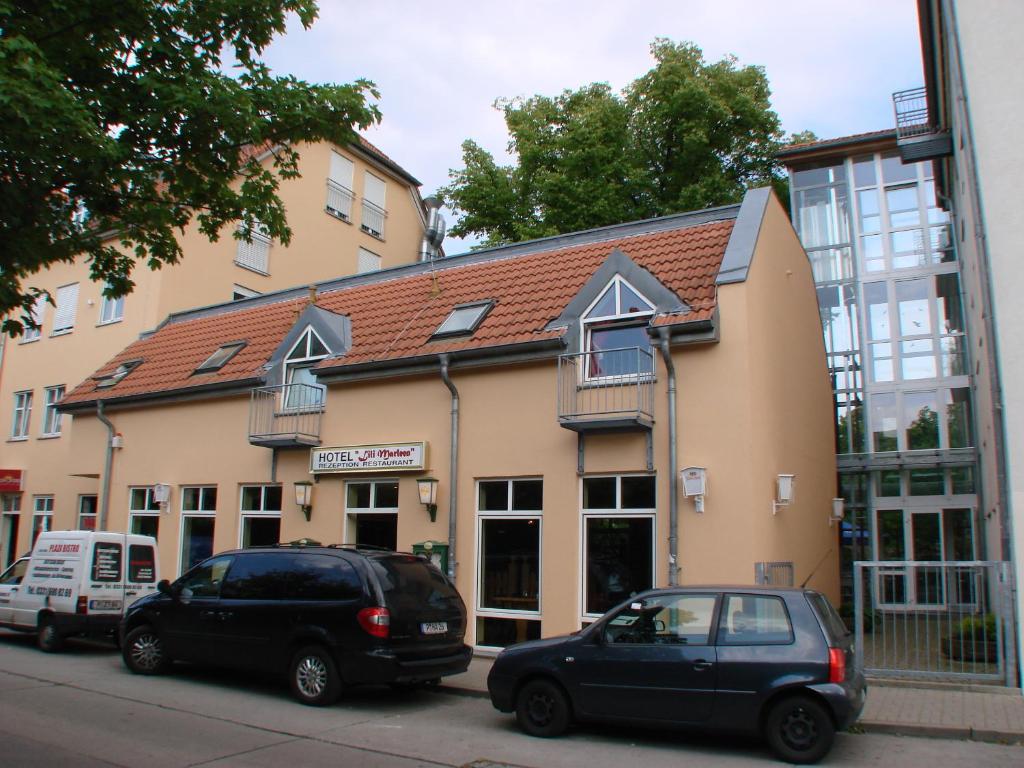 two cars parked in front of a building at Filmhotel Lili Marleen in Potsdam