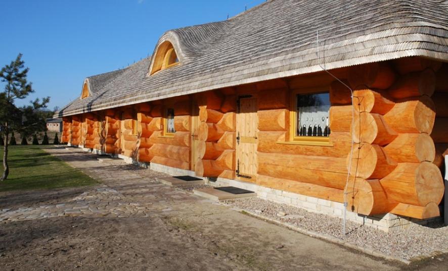 a log cabin with a wooden wall on the side at Pod Koziorożcami in Trzebiechów