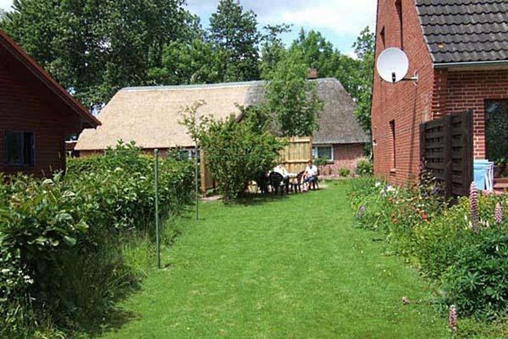 a yard with a building and a table and chairs at Haus Gode Sünn in Tating