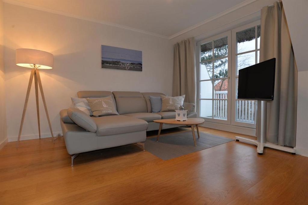 ein Wohnzimmer mit einem Sofa und einem Flachbild-TV in der Unterkunft Haus Wattläufer - Lütte Koje in Sankt Peter-Ording